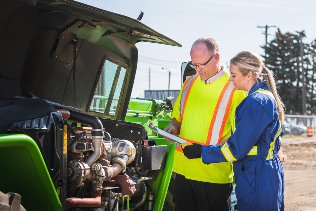 Two workers looking at a clipboard.